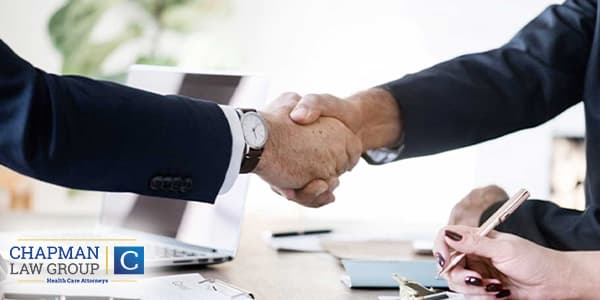 Image of a doctor and a healthcare defense attorney shaking hands.