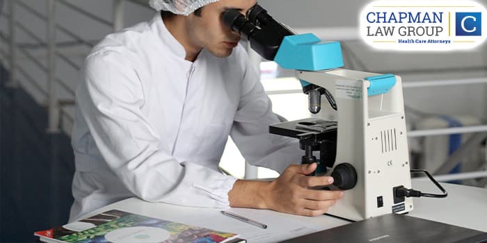 A lab doctor looking through a microscope.