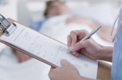 Image of a doctor filling out a form.