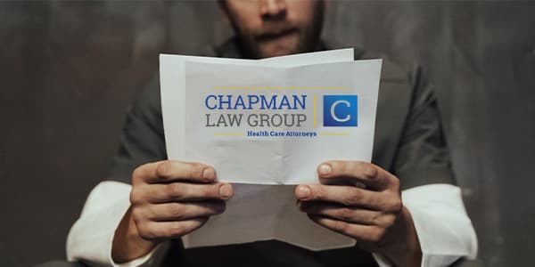 Defendant sitting in a jail cell reading about Chapman Law Group who could help reduce his sentence via Amendment 821, Post Conviction Relief